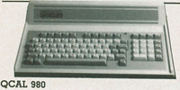 Vintage 1980s integrated system unit showing a dark grey layout with extended arrow cursor movement key groupings on a broad mechanical keyboard base.